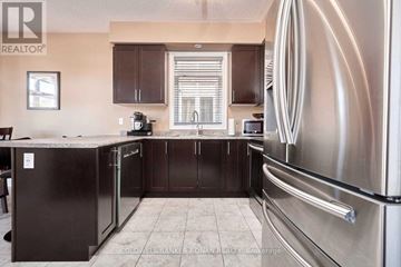 Barrie (Painswick South) apartment for rent - A kitchen with a stainless steel refrigerator and dark brown cabinets.