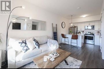 Hamilton (Waterdown) townhouse for rent - A modern living room with a white couch and a wooden coffee table.