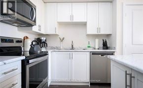 Hamilton (Waterdown) townhouse for rent - A kitchen with white cabinets and a black stove top.