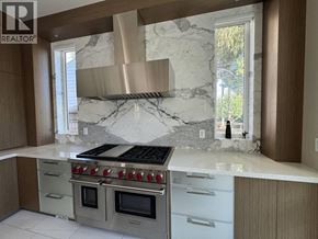 Vancouver apartment for rent - A modern kitchen with a stainless steel stove and marble countertops.