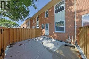 Sarnia townhouse for rent - A sunny day at a newly constructed brick house with a wooden fence.
