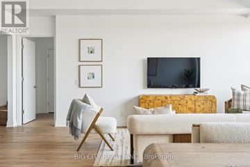 Toronto (Thorncliffe Park) condo for rent - A living room with a white couch and a yellow headboard.