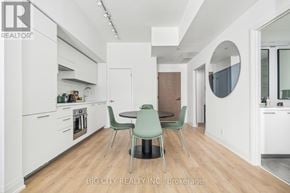 Toronto (Thorncliffe Park) condo for rent - A modern kitchen with white cabinets and a wooden floor.