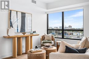 Toronto (Thorncliffe Park) condo for rent - A living room with a couch, a chair, a coffee table, and a large window with a view of the city.