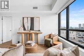 Toronto (Thorncliffe Park) condo for rent - A living room with a large window overlooking a parking lot.