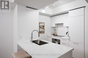 Toronto (Thorncliffe Park) condo for rent - A modern kitchen with white cabinets and a large island.
