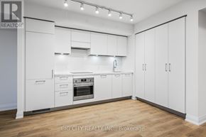 Toronto (Thorncliffe Park) condo for rent - A white kitchen with wooden floors and white cabinets.