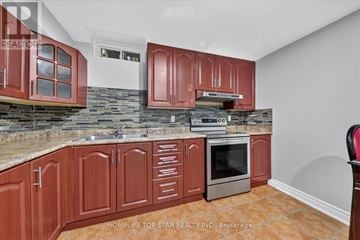 Toronto (Highland Creek) apartment for rent - A kitchen with red cabinets and a stone backsplash.