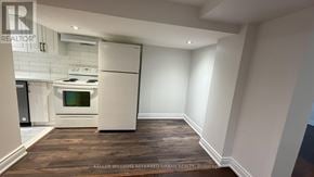 Toronto (Yorkdale-Glen Park) apartment for rent - A modern kitchen with white appliances and a wooden floor.