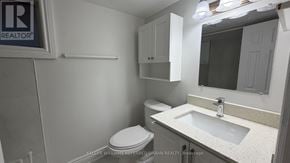 Toronto (Yorkdale-Glen Park) apartment for rent - A bathroom with a toilet, sink, and mirror.