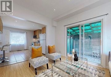 Brampton (Downtown Brampton) apartment for rent - A living room with a glass table and two chairs with orange cushions.