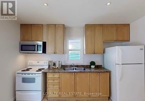 Brampton (Downtown Brampton) apartment for rent - A kitchen with wooden cabinets and a white refrigerator.