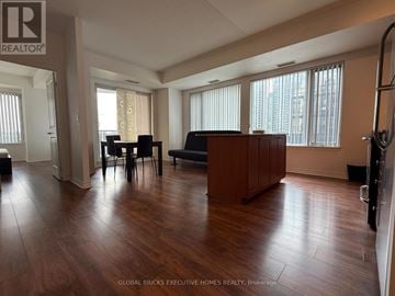 Mississauga (City Centre) condo for rent - A living room with a brown couch and a dining table with chairs.