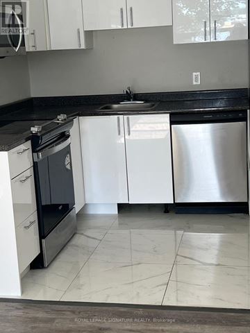 Whitchurch-Stouffville apartment for rent - A kitchen with white cabinets and a black countertop.