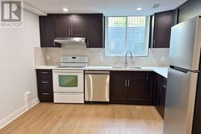 Clarington (Courtice) apartment for rent - A kitchen with dark brown cabinets and white appliances.