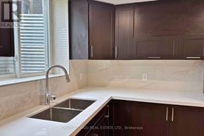 Clarington (Courtice) apartment for rent - A kitchen with brown cabinets and a white countertop.