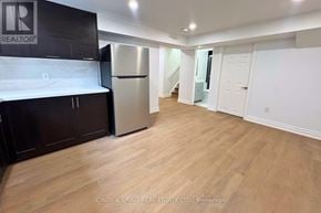Clarington (Courtice) apartment for rent - A kitchen with a refrigerator and wooden floors.