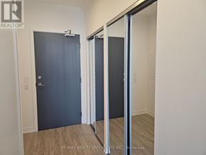 Mississauga (Central Erin Mills) condo for rent - A room with a sliding door and a wooden floor.