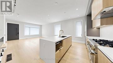 Toronto (Yorkdale-Glen Park) townhouse for rent - A modern kitchen with wooden cabinets and a central island.