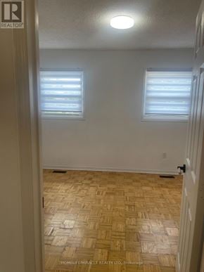 Brampton (Northwood Park) apartment for rent - A room with wooden flooring and two windows.