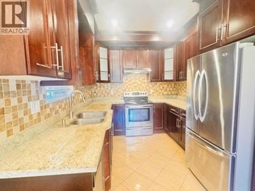Vancouver apartment for rent - A kitchen with a tile backsplash and a stainless steel refrigerator.