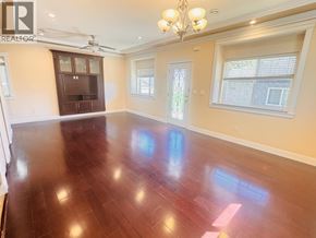 Vancouver apartment for rent - A large empty room with wooden floors and a chandelier.