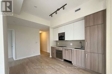 Toronto (Church-Yonge Corridor) condo for rent - A modern kitchen with wooden cabinets and a microwave above the stove.