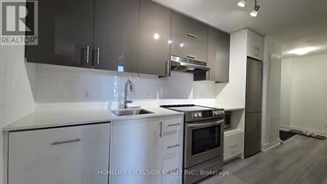 Toronto (Don Valley Village) condo for rent - A modern kitchen with white cabinets and stainless steel appliances.