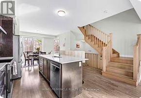 Brampton (Credit Valley) townhouse for rent - A modern kitchen with a stainless steel island and wooden staircase.