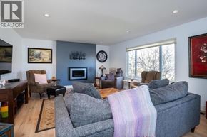 Delta apartment for rent - A living room with a grey couch and a fireplace.