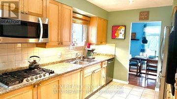 Pickering (Bay Ridges) apartment for rent - A kitchen with wooden cabinets and a stove top oven.