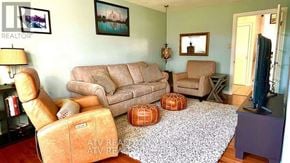Pickering (Bay Ridges) apartment for rent - A living room with a couch, chair, ottoman, and lamp.