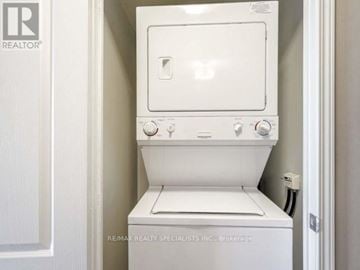 Mississauga (City Centre) condo for rent - A white oven with a door open is in a small kitchen.
