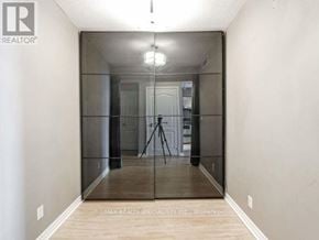 Mississauga (City Centre) condo for rent - A hallway with a glass door and a tripod in the middle.