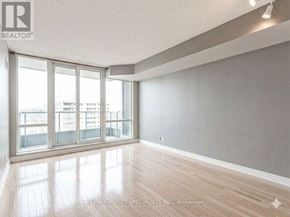 Mississauga (City Centre) condo for rent - A spacious room with wooden flooring and large windows.