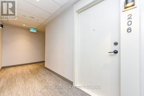 Milton (Co Coates) condo for rent - A white door with the number 206 on it is in a room with a carpeted floor.