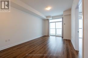 Hamilton (Waterdown) condo for rent - A room with wooden floors and a large window.