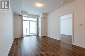 Hamilton (Waterdown) condo for rent - A room with wooden floors and white walls, with a window on the left side.