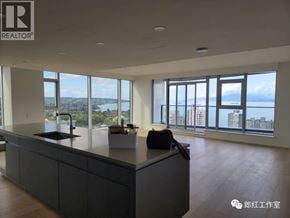 Vancouver apartment for rent - A modern kitchen with a large island and a view of the city.