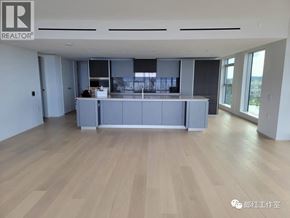 Vancouver apartment for rent - A spacious room with wooden flooring and a large island in the middle.
