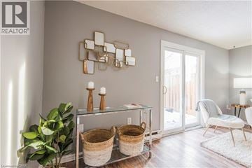 Kitchener townhouse for rent - A modern living room with a glass table and a mirrored wall art.