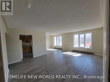 Cramahe (Colborne) apartment for rent - A spacious room with wooden flooring and a large window.