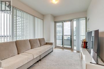 Toronto (Mimico) condo for rent - A living room with a beige couch and a flat screen TV.