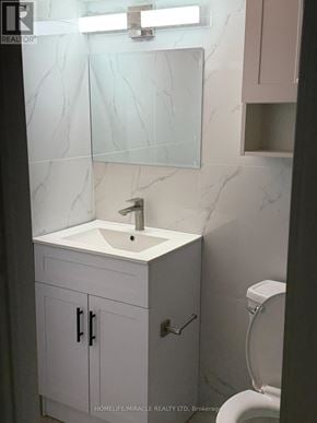 Toronto (Eglinton East) apartment for rent - A bathroom with a sink, mirror, and toilet.