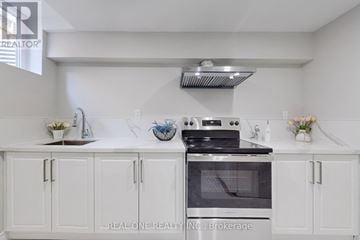 Whitby (Rolling Acres) apartment for rent - A white kitchen with a stove and cabinets.