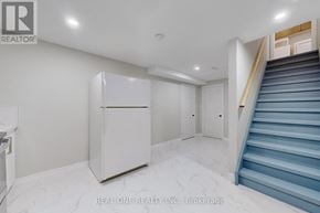 Whitby (Rolling Acres) apartment for rent - A white refrigerator in a room with a staircase.