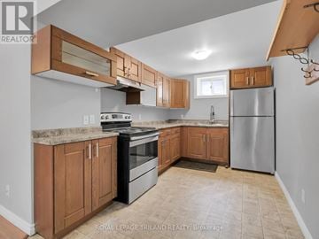London East (East F) apartment for rent - A kitchen with wooden cabinets and a black stove top oven.
