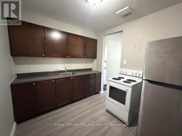London East (East H) multi-family for rent - A kitchen with brown cabinets and a white stove.