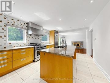 Toronto (Banbury-Don Mills) apartment for rent - A modern kitchen with wooden cabinets and a marble island.