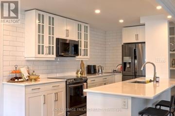 London East (East F) condo for rent - A modern kitchen with white cabinets and appliances.